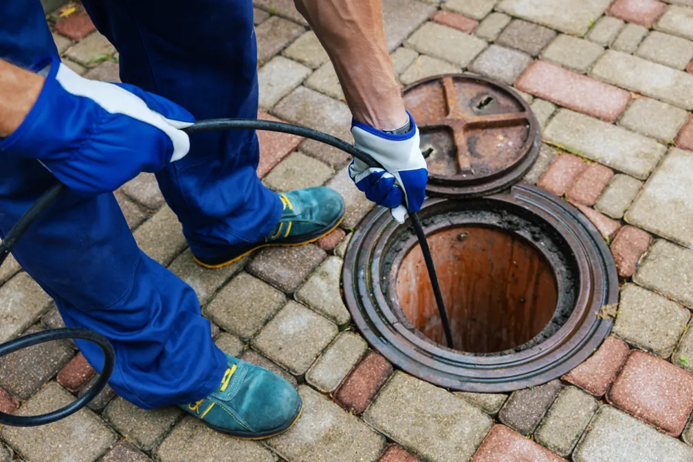 Plumber clearing a sewer line through a cleanout